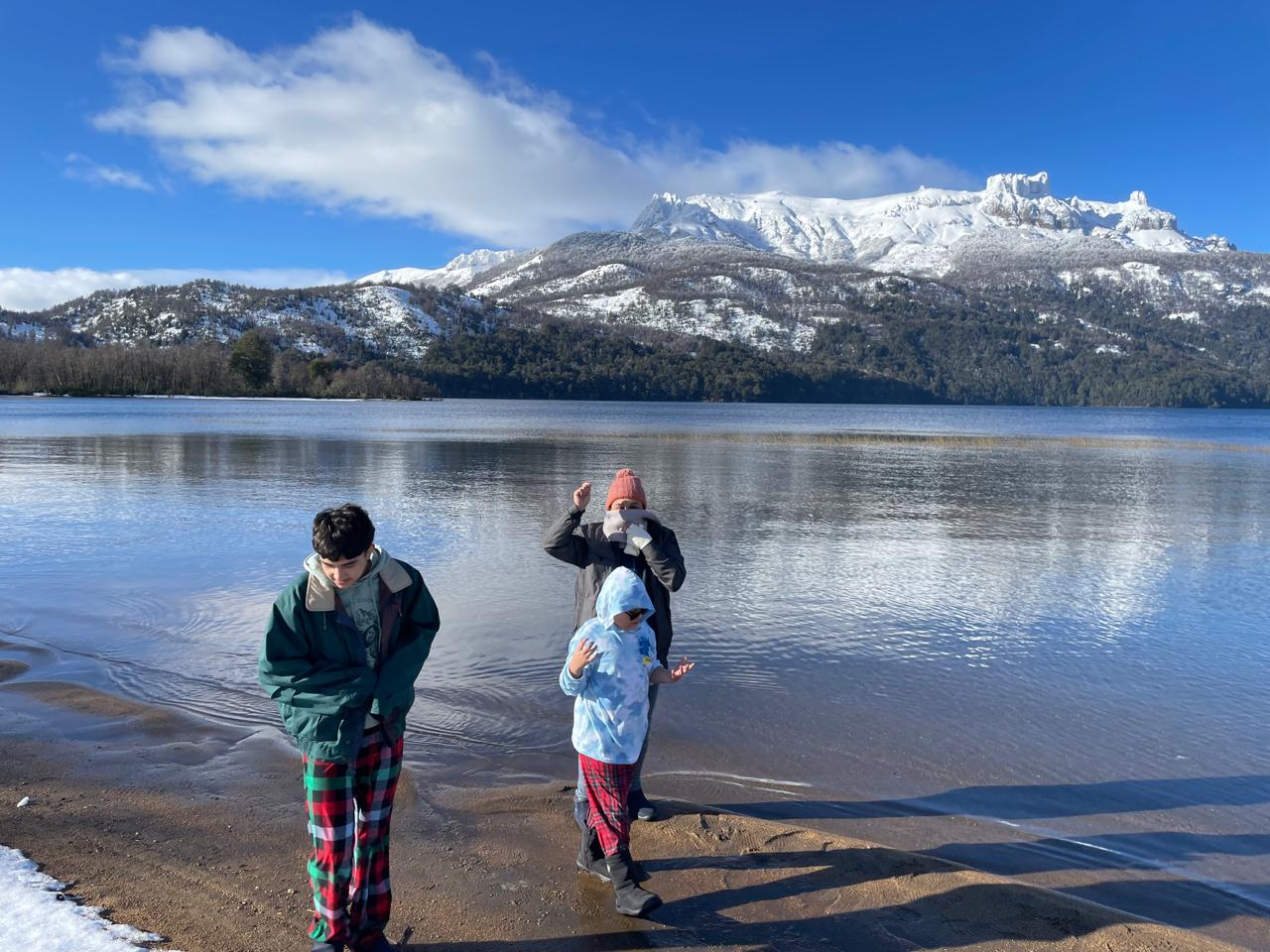 Viajeros junto a un lago y montañas en Bariloche, Argentina